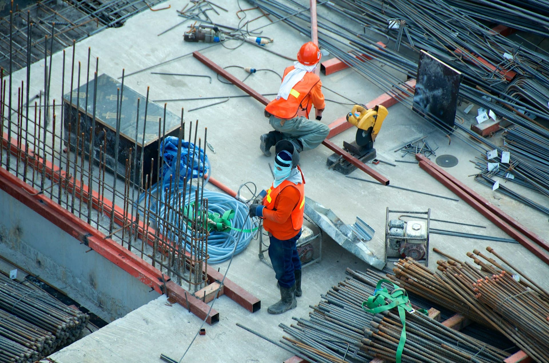 Workers cutting and arranging reinforcing steel at a construction site